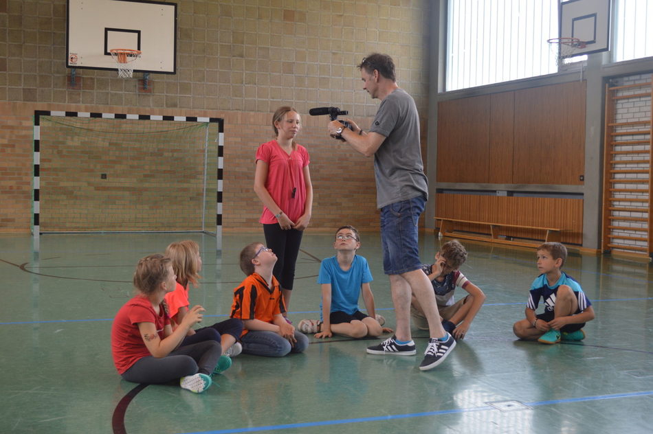 Film-Abschlussprojekt: "Dreamjob"Schüler als Schauspieler, Drehbuchautoren und Filmproduzenten Dreamjob - Auf dem Weg zum Traumberuf        „Unsere Schule – welche Möglichkeiten und Chancen wir dadurch haben…“  Mit diesem Motto machte sich die gesamte Private Grund- und Mittelschule an ein Filmprojekt, das über acht Wochen lief.  Kerngedanke: Was will ich später einmal werden und wie hilft mir diese Schule dabei, meinem Traumberuf ein Stück näher zu kommen.  Somit entstanden acht Projektgruppen, die sich jeden Dienstag und Donnerstag am Nachmittag in der Projektzeit trafen. Dort lernten sie einiges über das Thema Film, Filmdreh und wie es hinter den Kulissen bei einer Filmproduktion zugeht.  Während der weiteren Projektzeit schrieb jede Projektgruppe ein individuelles Drehbuch, das die Tätigkeit eines Traumberufes darstellt und eine Unterrichtsszene, die dafür förderlich ist. Nachdem diese Szenen nach den jeweiligen Drehbüchern eingeübt wurden, kam der Fachmann Sven Dahnk, der Vater eines Jungen aus der Adlerklasse, und filmte diese mit großer Professionalität und dem dafür erforderlichen Equipment.  Aus dem gesammelten Filmmaterial schnitt unser Fachmann einen Film zusammen.  Die große Filmpremiere fand in der letzten Schulwoche vor den Sommerferien für die Schüler und Eltern statt.
